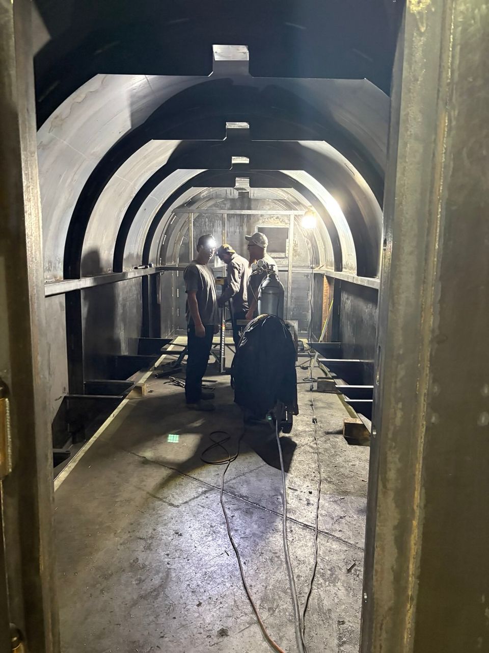 Team members welding or fabricating in the shop